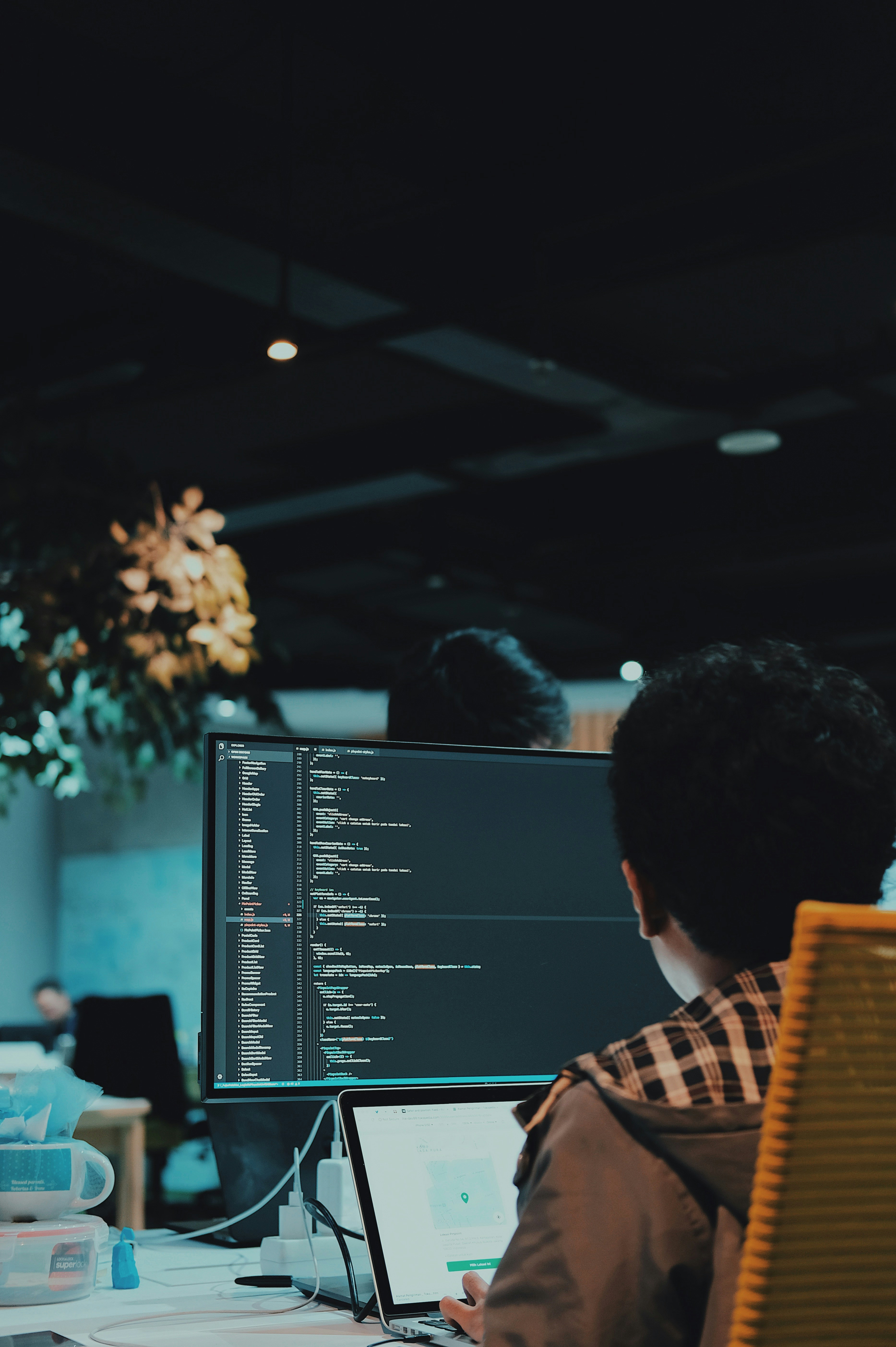 Developer working at a monitor with code on screen